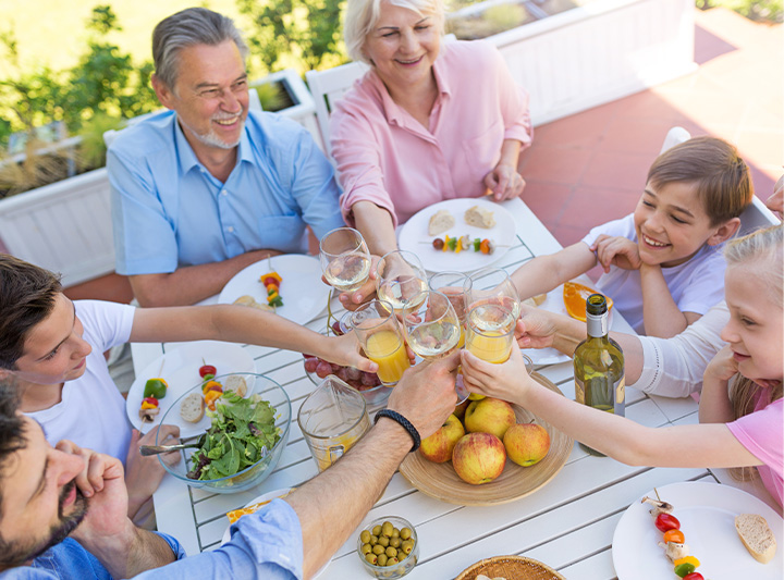 A happy family eating lunch outdoors in a sunroom